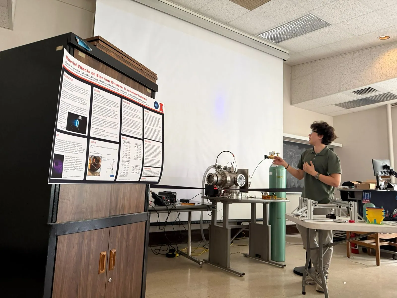 A member presenting beside the research poster and IonSpark setup