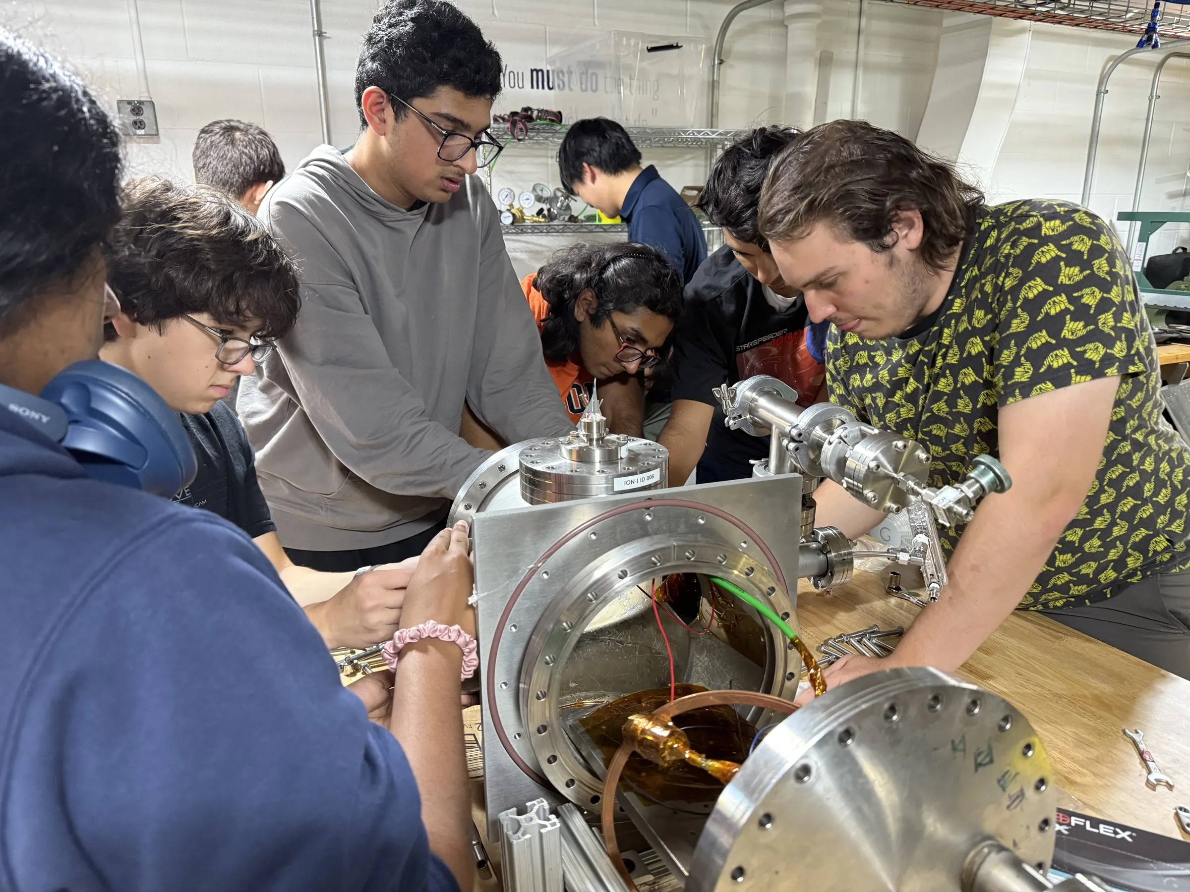 Members assembling hardware on the vacuum chamber