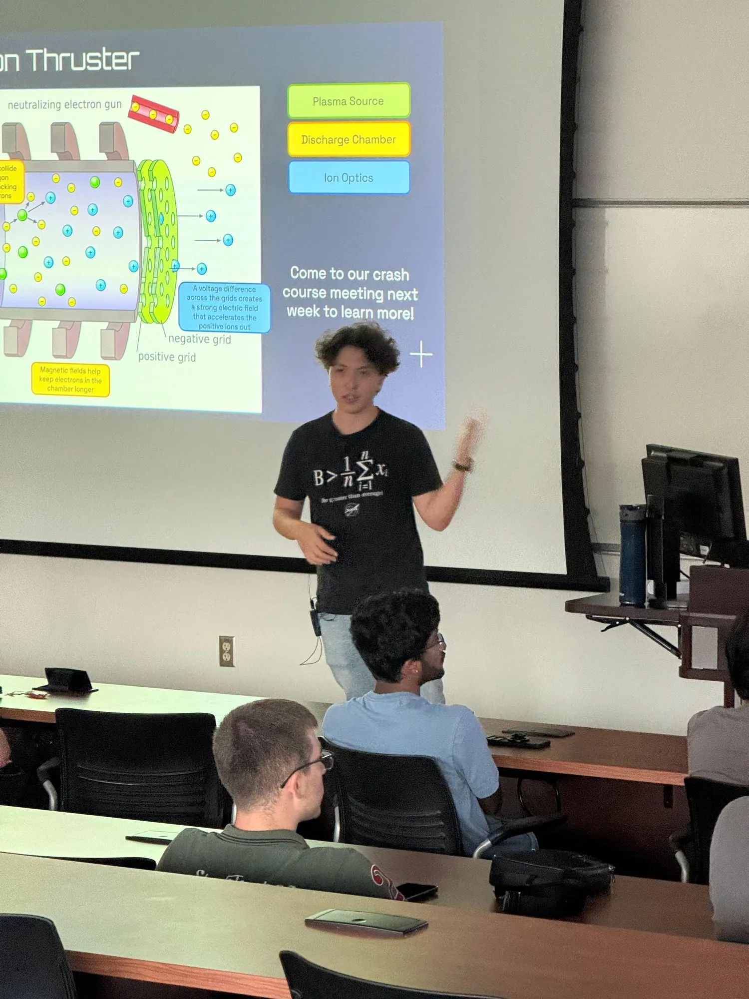 A member explaining a gridded ion thruster diagram