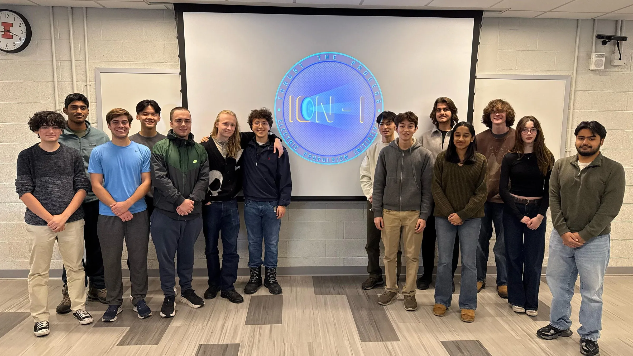 ION-I members standing in front of the club logo